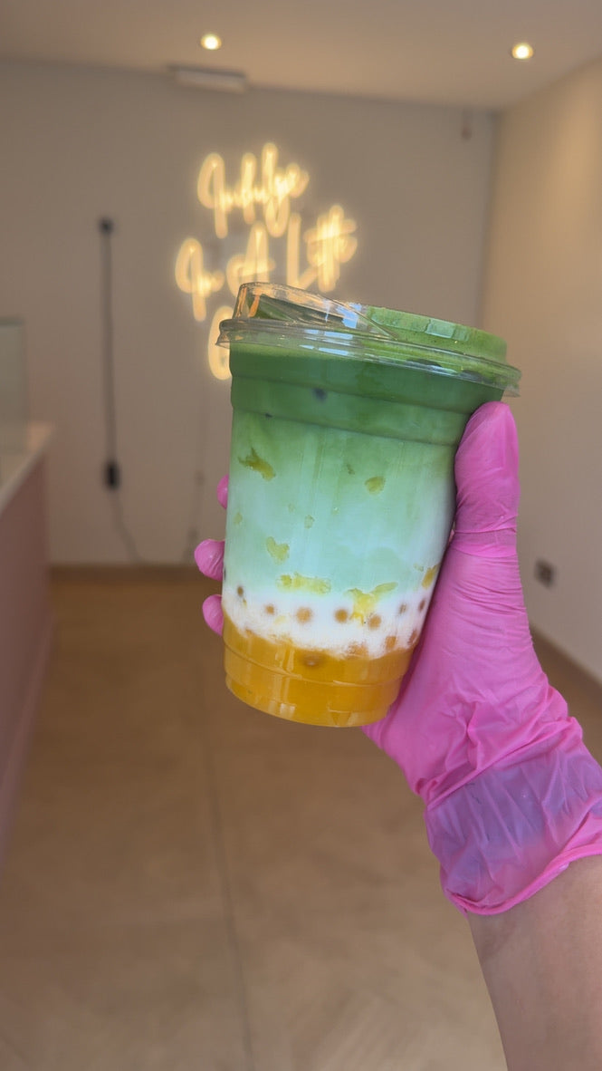 Layered green iced drink with a golden fruit layer at Bonnies Glamour Bakes